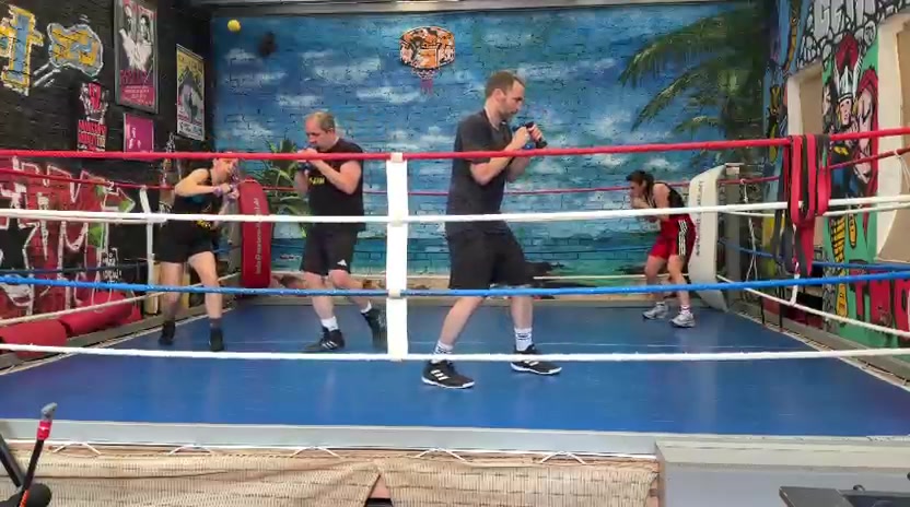 Mehrere Personen beim Boxtraining im Ring
